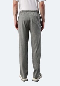 Graue Jogginghosen aus weichem Stoff, mit einem elastischen Bund, einer Gesäßtasche und einer lockeren Passform, die sich an den Knöcheln verjüngt.