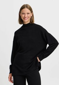 Pulover lung negru cu mâneci lungi, guler înalt, croială lejeră și mansete strâmte. Textură moale și fante laterale pentru confortul mișcării.