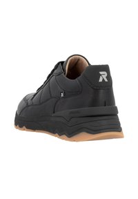 Zapatilla deportiva negra con parte superior de cuero texturizado, cuello acolchado y suela de goma resistente con un patrón en zigzag distintivo.