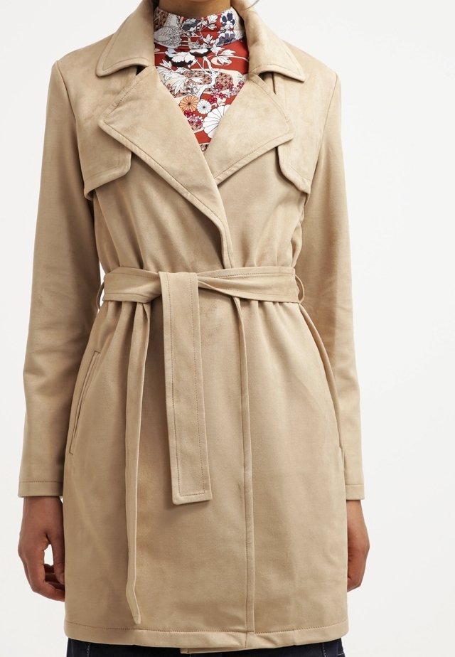Beige imitationssuede trenchcoat med slagkrage, knytliv och sidofickor. Har en medellång passform och en mjuk textur.