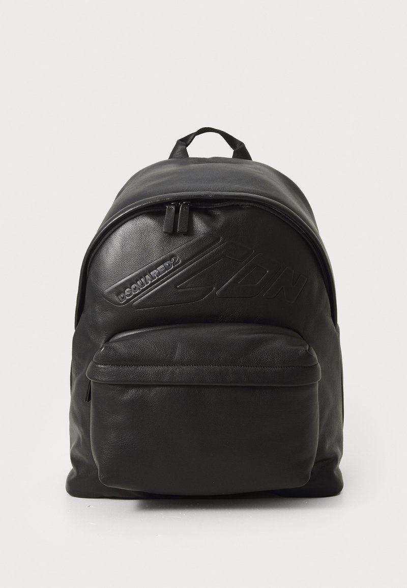 Black leather backpack with a rounded shape, featuring a front zip pocket and textured logo detail. Smooth finish and dual front zippers.