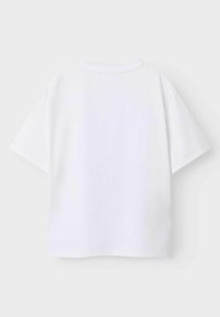 Płaska, biała koszulka z krótkim rękawem, z widokiem na tył i okrągłym dekoltem, na jasnoszarym tle.