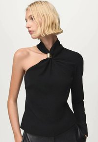 Top negro con diseño asimétrico, un hombro descubierto, detalle de nudo en el cuello y un acento dorado. Tejido suave con silueta ajustada.