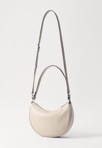 Beige læder skuldertaske med en buet form, der har lynlåslukning og justerbar rem. Glat tekstur med minimal hardware.