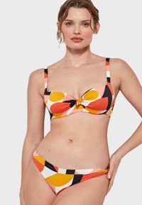 Conjunto de bikini con un estampado multicolor que presenta grandes círculos en rosa, naranja, amarillo y negro. La parte superior tiene un detalle de nudo en el centro.