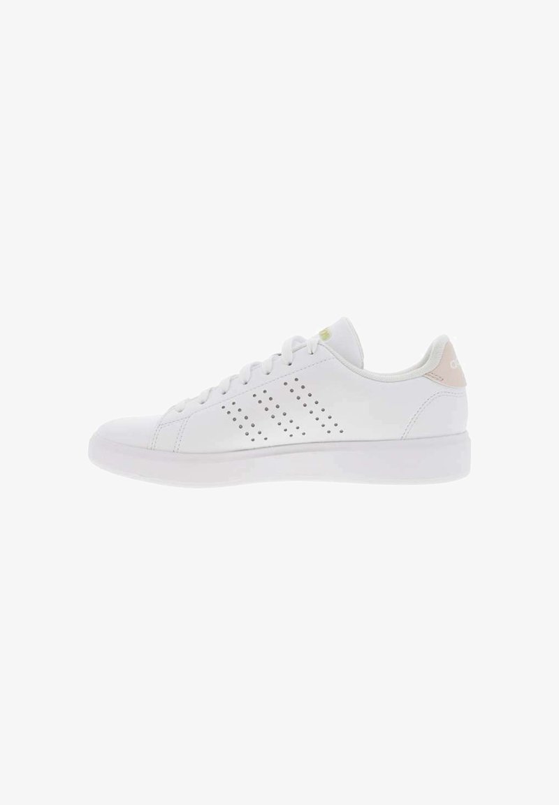Zapatilla deportiva blanca con diseño perforado en el costado, puntera redondeada, suela plana y un sutil acento rosa en el talón.