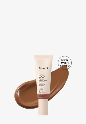 Tube de Dr.Jart+ BB Premium Beauty Balm avec SPF 50+ en teinte bronzage profond, avec un échantillon de crème marron derrière et une étiquette SPF 50.