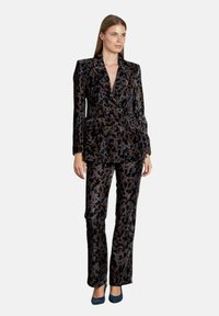 Samtanzug mit Leopardenmuster in dunklen Tönen, bestehend aus einem doppelt geknöpften Blazer und geraden Hosen, versehen mit eleganten Knöpfen und einer glatten Textur.