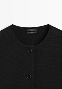 Cardigan in cotone nero lavorato a maglia con scollo rotondo e due bottoni neri sul davanti, etichettato Massimo Dutti, made in China.
