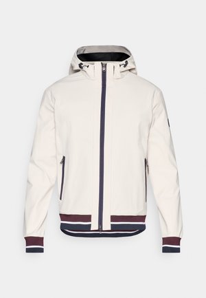 Veste beige clair avec capuche, présentant une fermeture éclair à l'avant, deux poches zippées, et des poignets et un ourlet côtelés avec des rayures bleu marine et bordeaux.