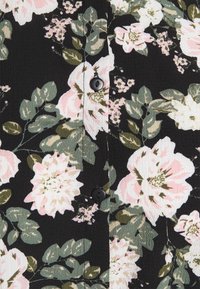 Blusa floreale con sfondo nero, fiori rosa e bianchi, foglie verdi, tessuto testurizzato e dettaglio di bottoni neri.