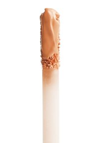 Liquid concealer with a smooth, creamy orange-brown formula, applied on a foam applicator with textured tip and a tapered white handle.