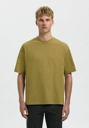 Oliven grøn bomulds t-shirt med korte ærmer, rund hals, afslappet pasform og glat tekstur. Har lette sideslidser i kanten.