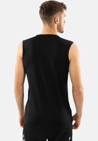 Schwarzes ärmelloses Sportshirt aus strukturiertem Stoff. Es hat einen Rundhalsausschnitt und eine lockere Passform, die sich für körperliche Aktivitäten eignet.