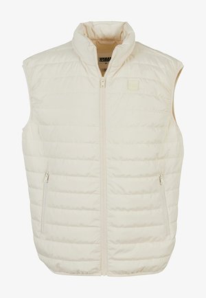 Puffervest in off-white met hoge kraag, ritssluiting aan de voorkant en twee zijzakken. Heeft een doorgestikte textuur en subtiele branding.