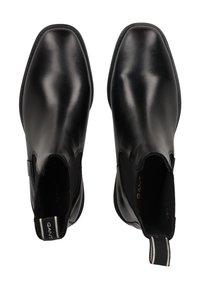 Stivali Chelsea in pelle nera con pannelli elastici laterali, punta arrotondata, texture liscia e linguetta in tessuto a contrasto sul retro.