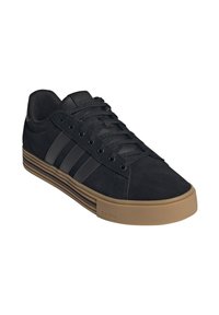 Sneakers in suede nere con tre strisce nere, design slip-on e suola in gomma marrone. Presentano una tomaia testurizzata e un interno imbottito.