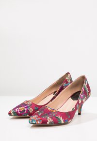 Décolleté in satin bordeaux con stampa floreale, punte affusolate e tacchi da 2 pollici. Presentano colorati ricami floreali e una finitura liscia.