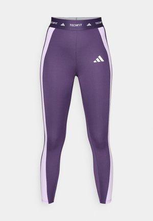 TechFit legingi dziļi violetā krāsā ar gaiši violetām sānu paneļiem. Izgatavoti no elastīga materiāla, ar elastīgu jostasvietu un Adidas logo.
