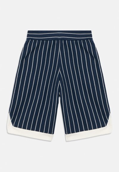 Σορτς σε ναυτικό μπλε χρώμα με κάθετες λευκές ρίγες, διαθέτει φαρδιά ελαστική μέση και λευκά τελειώματα στο τελείωμα. Απαλό, αεριζόμενο ύφασμα.
