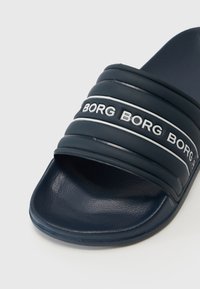 Námorníckomodré šlapky s tromi embosovanými pruhmi s textom "BORG", vyrobené z textúrovaného gumového materiálu, s otvorenou špičkou.