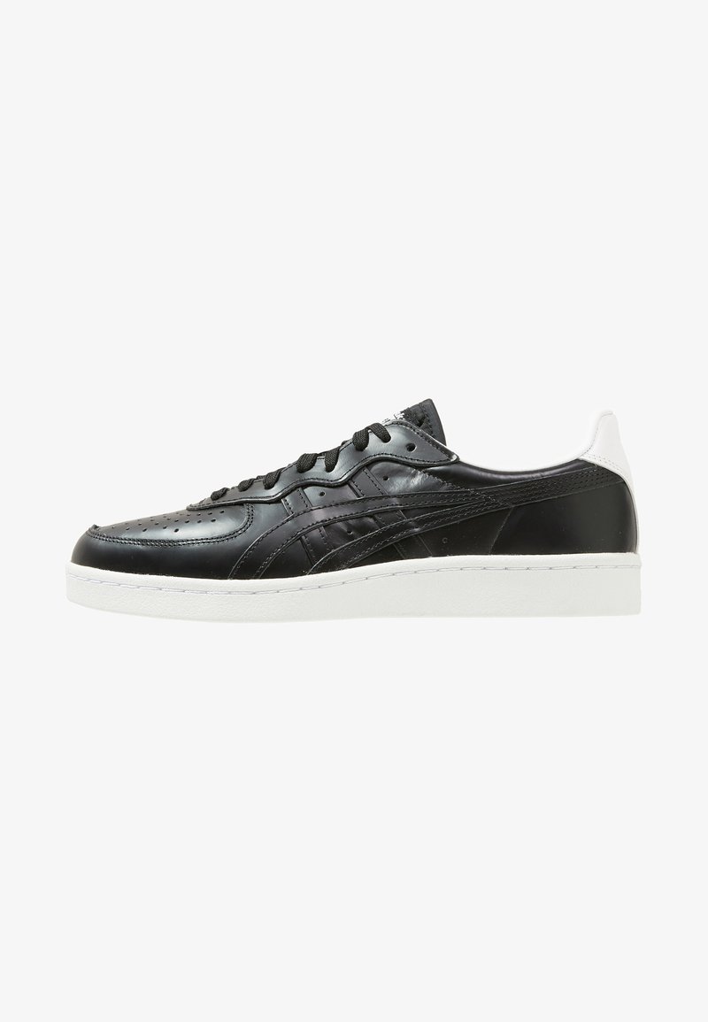 Sneaker in pelle nera con finitura liscia, suola bianca e punta perforata. Presenta lacci e dettagli neri, con un tab del tallone bianco a contrasto.