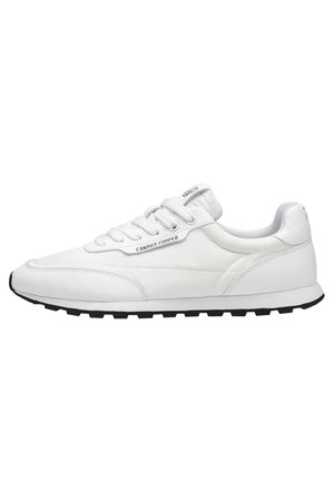 White low-top sneaker with lace-up design, cushioned collar, black textured sole, and "Candice Cooper" branding on the side.