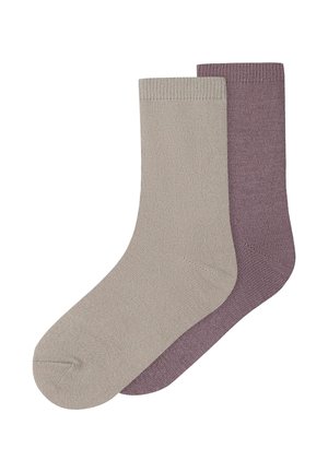 Deux chaussettes unies en maille, l’une beige clair à l’avant et l’autre violet atténué à l’arrière, présentées à plat sur fond blanc.