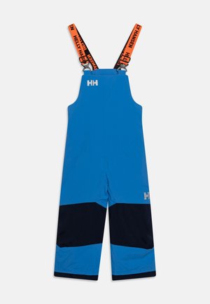 Salopettes imperméables bleues avec des accents de panneaux noirs et bleus. Dotées de bretelles ajustables orange et noires, avec un détail de logo à l'avant.