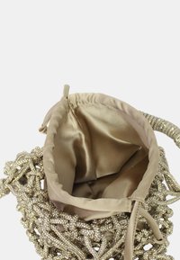 Borsa metallica con perline e interno in raso beige, caratterizzata da apertura superiore e chiusura con coulisse, che mostra dettagli testurizzati e intricati.