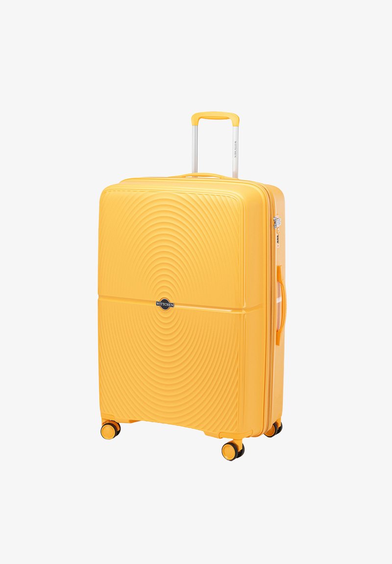 Žlutý tvrdý kufr s vlnkovým vzorem, vybavený teleskopickou rukojetí, čtyřmi koly a boční rukojetí pro snadnou manipulaci.
