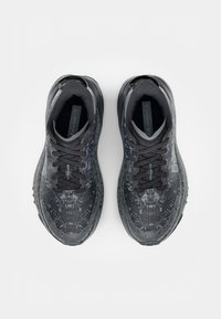 Black athletic shoes with a textured design, featuring tonal abstract patterns, flat laces, and a cushioned sole.