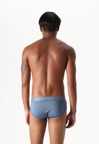 Blå herrunderkläder med en grå midja som har varumärket "DLP". Slät tyg, snug passform och minimalistisk design.