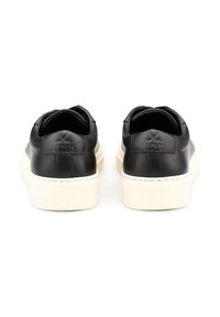 Czarne skórzane sneakersy z kontrastującymi białymi gumowymi podeszwami. Okrągłe noski i wyściełany kołnierz, z wypukłym detalem logo z tyłu.