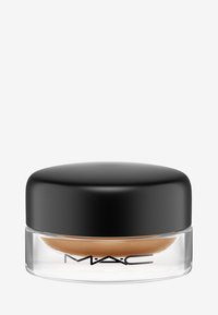 Glazen pot met een zwarte ronde deksel, gevuld met een bruine crème. Heeft een zachte textuur en het MAC-logo aan de voorkant.