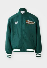Grøn varsityjakke med trykknaplukning, hvide striber på ærmer og nederkant samt broderet "Carhartt Ducks" logo med et basketballgrafik.