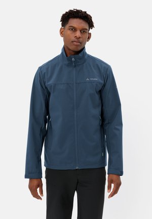 Veste softshell bleu marine avec un col montant, une fermeture éclair à l'avant et des poches latérales. Présente un logo minimaliste et une texture lisse.