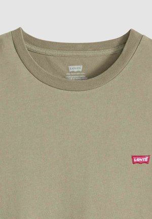 Beige Levi's T-shirt met ronde hals, rood logo op linkerborst, zichtbare kraagstiksels en een bedrukte binnenlabel.