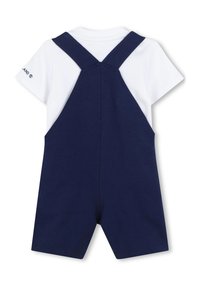 Pantaloni corti blu navy con bretelle elastiche sopra una maglietta bianca, con maniche corte e un dettaglio del logo su una manica. Texture liscia.