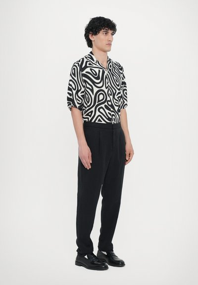 Black and white short-sleeve shirt featuring a swirled pattern, paired with black tapered trousers and black shoes. Simple and modern design.