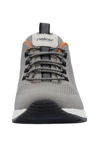 Graue Sportschuh mit einem gestrickten Obermaterial, strukturierten Oberflächen, schwarzen Schnürsenkeln, orangefarbenen Akzenten und einer schwarzen Sohle mit einer weißen Zwischensohle.