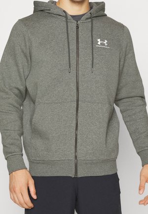 Felpa grigia con zip realizzata in tessuto morbido, dotata di un cappuccio con cordini e un piccolo logo sul petto. Maniche e orlo aderenti.