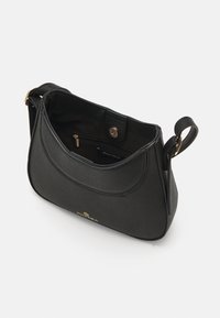 Mustakvainen Anna Field olkalaukku, jossa on säädettävä hihna, avonainen yläosa, joka paljastaa vetoketjullisen sisätaskun ja magneettilukon.