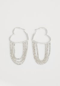 Pendientes de aro plateados en forma de corazón, con hebras en cascada de strass transparentes que aportan un brillo y textura adicionales.
