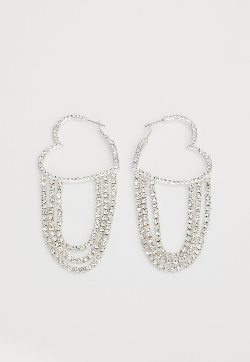 Pendientes de aro plateados en forma de corazón, con hebras en cascada de strass transparentes que aportan un brillo y textura adicionales.