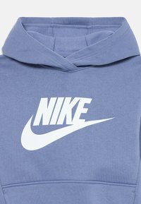 Nike kapuca v svetlo modri barvi, z belim logotipom in swooshom. Narejena iz mehkega materiala z kenguru žepom in nastavljivo kapuco.