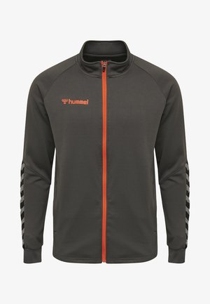 Dunkelgraue Zip-Jacke mit orangenen Akzenten, strukturiertem Stoff, Stehkragen und schwarz-weißen Zickzackstreifen an den Ärmeln.