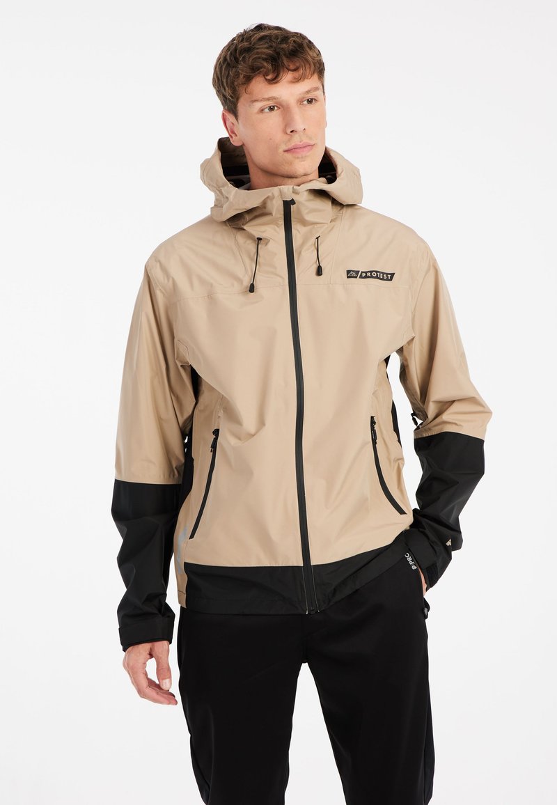 Beige och svart vattentät jacka med huva, dragkedja fram, justerbara snoddar och logotypdetalj på bröstet. Texturerad tyg.