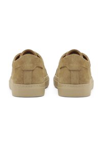 Zapatillas de ante marrón con suela de goma plana, puntera redonda y tira en la parte trasera. Los acentos laterales presentan una textura sutil.