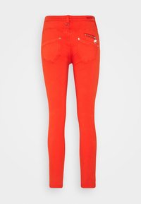 Rode skinny jeans met een gladde textuur, voorzien van een ritszak, twee achterzakken en een riemlus.